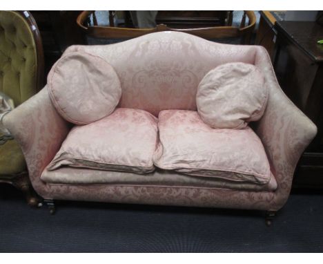 An Edwardian sofa upholstered in a pink damask fabric on square feet and castors, 130cm wide  