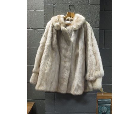 A ladies white fur coat with cuff arms  
