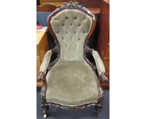 A Victorian button upholstered open arm easy chair, upholstered in grey material, with ornamental foliate and cartouche carve