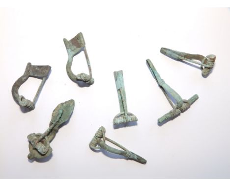 A collection of seven ancient Roman bronze brooches.
