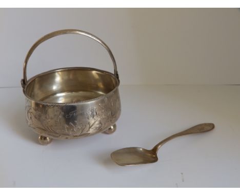 A Russian white metal swing-handled sugar bowl and a spoon. (2)