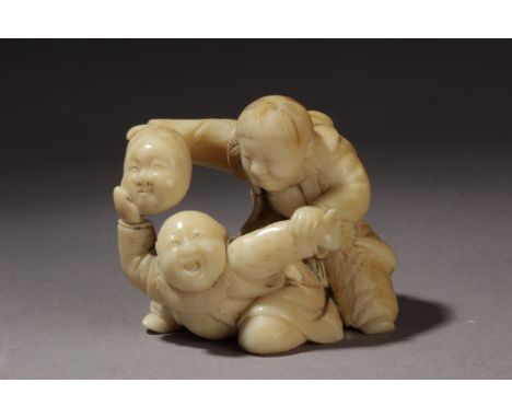 A mid 19th century Japanese netsuke from Edo period. Signed on the base. In carved ivory portraying a pair of boys playing wi