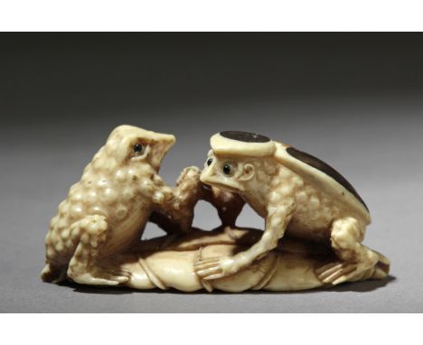 A late 19th century Japanese netsuke from Meiji period. Signed Tomokazu on the base. In carved ivory and shell with horn eyes