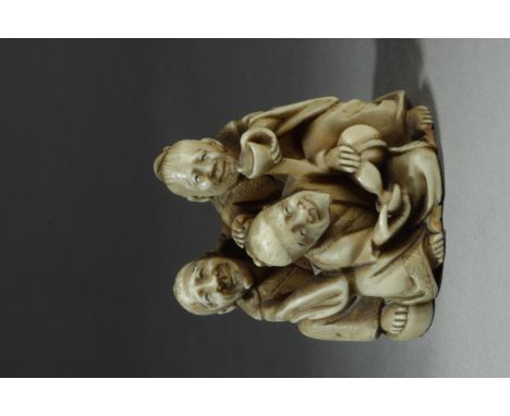 A mid 19th century Japanese netsuke okimono from Edo period. Signed Shuko on the base. In carved ivory depicting three sake d