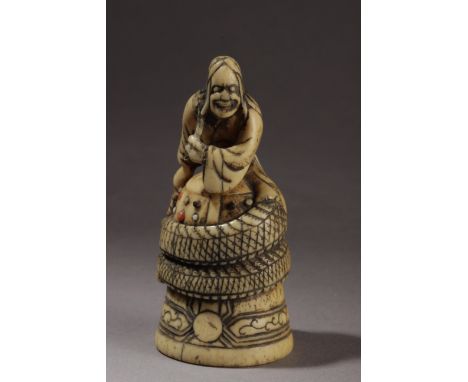 A Japanese netsuke from Edo period circa 1800. In carved ivory with coral and mother of pearl cabochons inlaid portraying "Ki