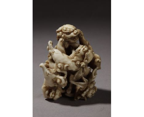 A 19th century Japanese netsuke . Signed Gyokusai on the base. In carved ivory portraying a group of four Shishis playing aro