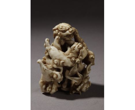 A 19th century Japanese netsuke . Signed Gyokusai on the base. In carved ivory portraying a group of four Shishis playing aro