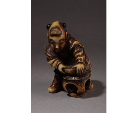 An early 19th century Japanese netsuke from Edo period. In carved ivory portraying a standing Karako with horn buns placing a