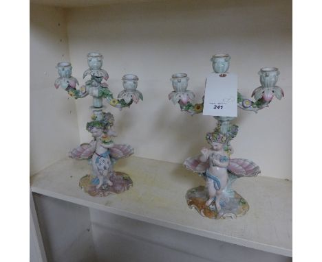 A pair of Meissen style candlestick with cherub and maiden relief
