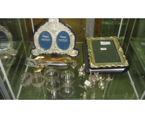 Shelf of assorted plated ware including plated photo frames, serviette rings 2 x silver tea spoons etc.