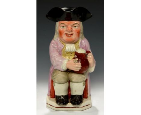 A STAFFORDSHIRE EARTHENWARE TOBY JUG, C1820  with ruddy, warty face in pink coat, 25cm h++Localised flaking of brown enamel a