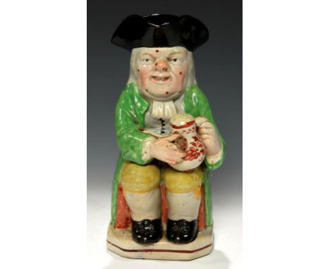 A STAFFORDSHIRE EARTHENWARE TOBY JUG, C1820-30  with warty face in bright green coat, 24cm h++Pipe slightly chipped, restorat