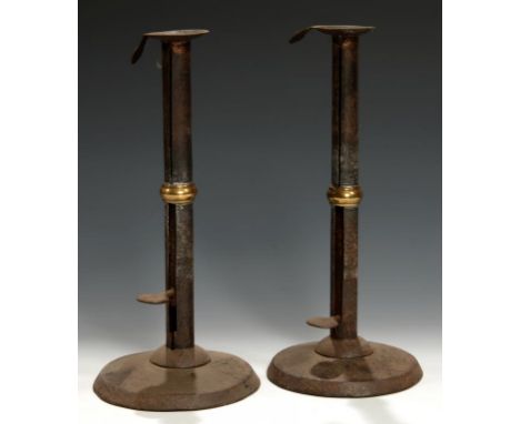A PAIR OF GEORGE III SHEET IRON AND BRASS MOUNTED 'HOG SCRAPPER' CANDLESTICKS, C1800 with sliding push-up, 27cm hFor an almos