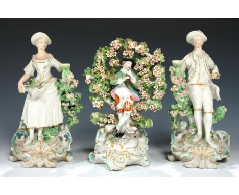 A PAIR OF DERBY CANDLESTICK FIGURES OF A SHEPHERD AND SHEPHERDESS AND A DERBY BOCAGE FIGURE OF A SHEPHERD PLAYING A RECORDER 