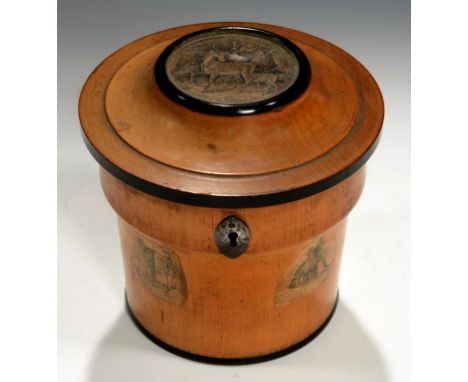AN UNUSUAL REGENCY CYLINDRICAL FRUITWOOD AND EBONISED TEA CADDY, C1800 inset and applied with cut paper engravings, steel esc
