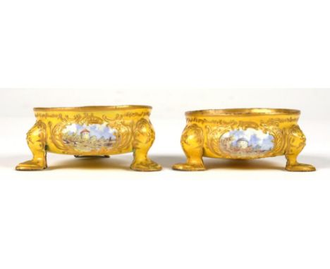 A PAIR OF CONTINENTAL YELLOW GROUND ENAMEL SALT CELLARS, LATE 19TH C  painted with three vignettes, 6cm diam++No substantial 