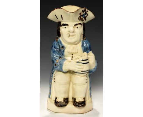 A STAFFORDSHIRE CREAMWARE TOBY JUG, C1790-1810  the toper smoking a clay pipe and holding a barrel shaped jug of foaming ale,