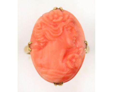 A 9ct gold carved coral cameo ring set with the profile portrait of a young woman in claw setting, size P.