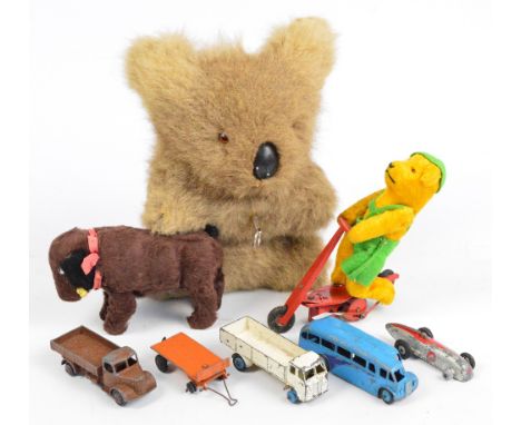 A mixed lot of toys comprising a koala with musical movement playing Waltzing Matilda, a bear on a tin plate scooter, a mecha