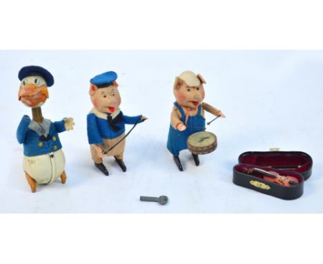 A pair of Schuco felt covered musician pigs, one playing the drum, one playing the violin, also a Schuco clockwork model of D
