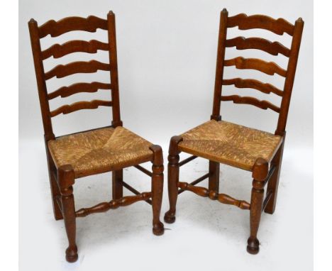 A set of four late 19th century wavy ladder back rush seated dining chairs raised on turned front legs.
