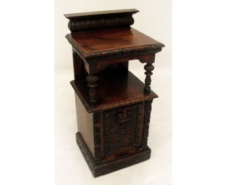 A late Victorian carved oak coal purdonium with upper shelf above fall front main section and plinth base, width 47cm. 