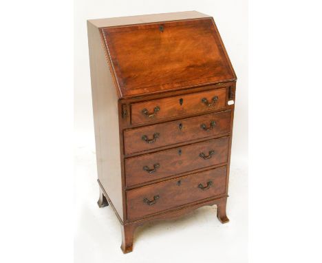 An Edwardian mahogany crossbanded bureau of small proportions, the hinged fall front enclosing a fitted interior above four g