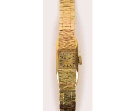 A Swiss 9ct yellow gold cased lady's wristwatch with textured decoration, the rectangular dial set with baton numerals, on 9c