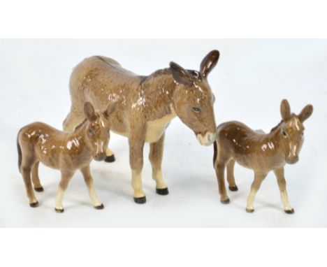 A Beswick trio of donkey and two foals. CONDITION REPORT: Appears good with no obvious signs of faults, damage or restoration