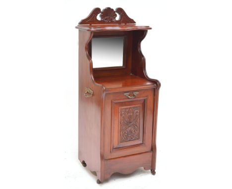 A late Victorian walnut coal purdonium with raised back and shelf above bevelled mirror and hinged carved fall down front sec
