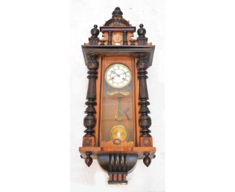 A German Vienna style eight day chiming wall clock in stained beech case, the circular enamel dial set with Roman numerals, h