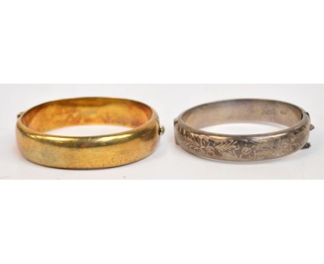 A hallmarked silver floral engraved snap bangle and a similar silver gilt example (2).