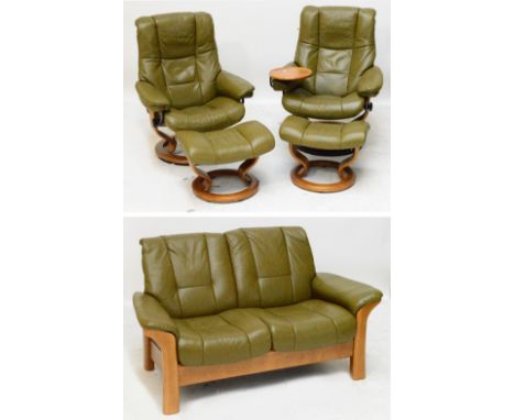 A modern leatherette and beech framed suite comprising a two seater sofa, a pair of swivel reclining armchairs and matching s