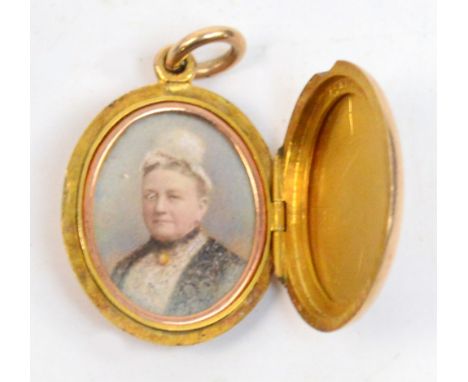 A 15ct gold oval locket pendant, the cover and back both engraved with initials opening to reveal a portrait of an elderly wo