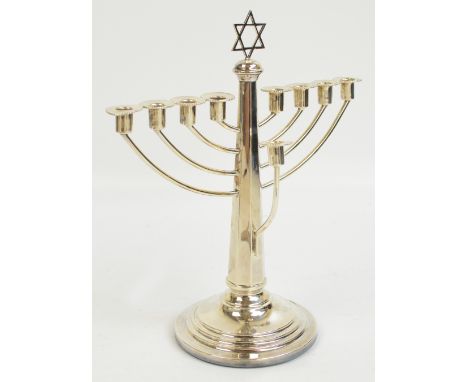 An Elizabeth II hallmarked silver hannukah menorah with octagonal tapering stem surmounted with a Star of David raised on ste