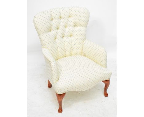 A contemporary button upholstered nursing chair raised on cabriole front legs.