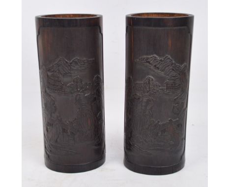 A pair of 19th century Chinese bamboo brush pots with carved decoration of bridges and pagodas and inscribed Chinese characte