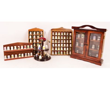A large collection of ceramic thimbles including several examples by Royal Crown Derby, Royal Doulton and Royal Albert, and m