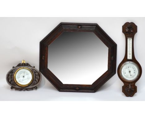 A carved oak small wheel barometer, a further oak framed barometer and an octagonal oak framed wall mirror (3).