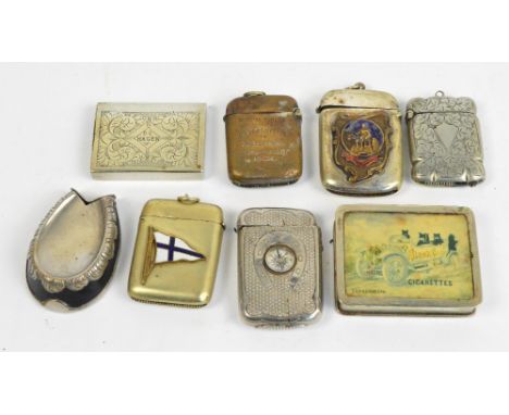 Eight vesta cases; a plated example with blue and white enamel flag, a base metal example set with horseshoe and compass, a p