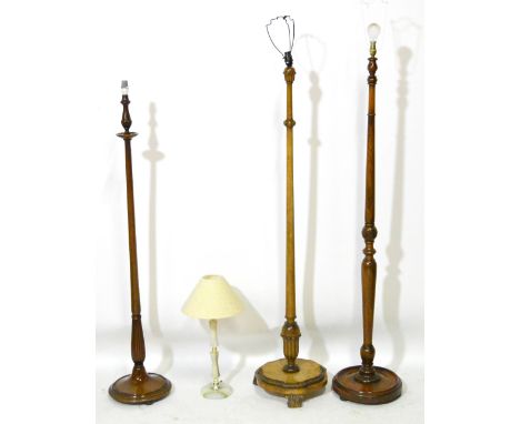 A carved walnut standard lamp, two similar examples and an onyx table lamp (4).