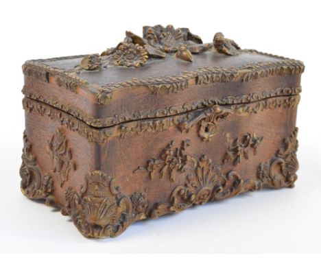 An unusual late 19th century American pressed oak tea caddy, the hinged lid surmounted with flowers enclosing two oak floral 