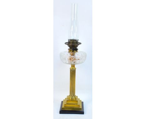 A late Victorian brass oil lamp with cut clear glass reservoir and fluted central column to stepped base, height including ch
