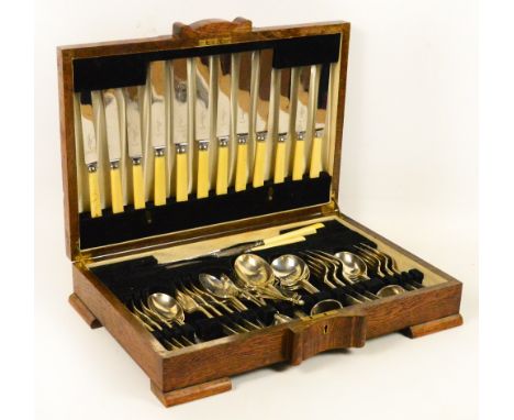 An oak cased canteen of electroplated Hanoverian pattern cutlery including a carving knife and fork, three napkin rings, etc,