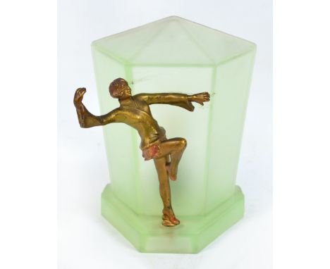 A French Art Deco lamp, the gilded spelter female figure standing on one leg before an angled pale green tinted frosted glass