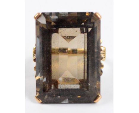 A 9ct yellow gold ring set with large emerald cut smoky quartz in high pierced mount, the quartz 2.5 x 1.5cm, size K/L.