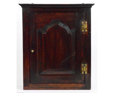 A George III oak spice cabinet, the fielded panelled door enclosing a shelf and arrangement of five small drawers with simple