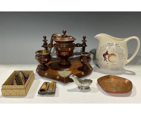 A late Victorian Gothic turned mahogany smoker's stand, the shield shaped base with brass rivets, urnular tobacco jar and cov