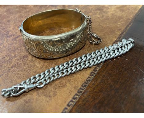 A gold on silver hollow cast hinged bangle, engraved and chased with foliate scrolls, 6.2cm in diameter; a silver curb link b