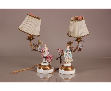 A pair of first half 20th century lamps, having Dresden porcelain figures on circular marble bases with brass branch stem lig